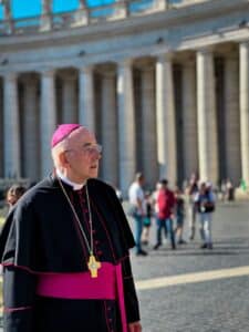 man in cassock standing on street