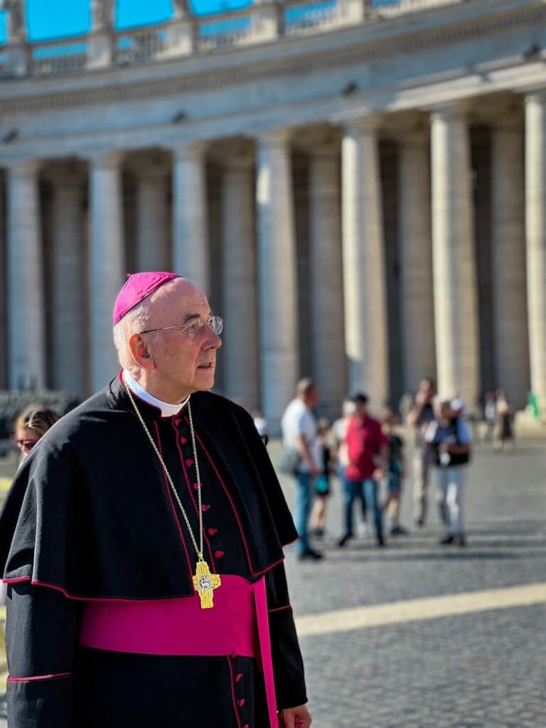 man in cassock standing on street
