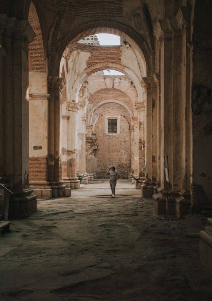 woman standing in the ruins of san jose cathedral in antigua guatemala