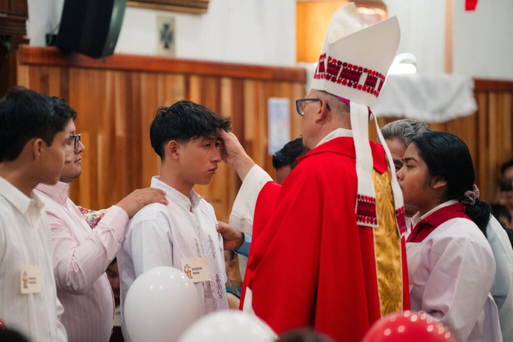 bishop performs confirmation ceremony in church
