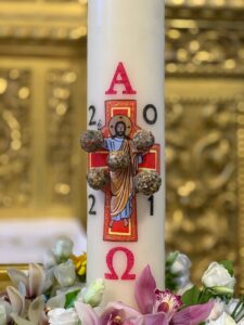 an easter candle surrounded by flowers